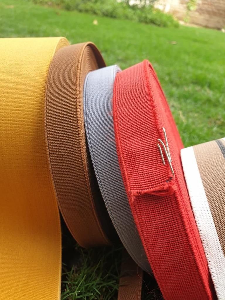 Mustard, brown, grey and red loom elastic rolls side by side